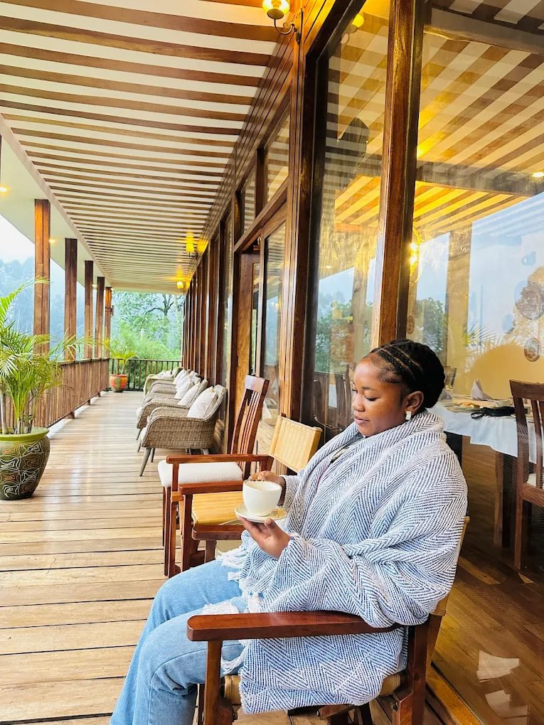 Guest enjoying panoramic forest views from private balcony at Four Gorillas Lodge Bwindi